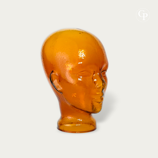 Tête mannequin vintage en verre moulé ambre cognac style Space Age 1970 vue de trois-quarts sur fond neutre | Vintage 1970s Space Age amber cognac molded glass mannequin head three-quarter view isolated on neutral background
