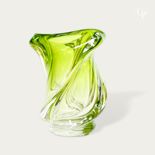 Vase en cristal vert Chartreuse modèle Conque par René Delvenne pour Val Saint Lambert 1956, sculpture de verre biomorphe mid-century modern sur un meuble en béton devant une fenêtre | Chartreuse green crystal Conque vase by René Delvenne for Val Saint Lambert 1956, mid-century modern biomorphic glass sculpture on a concrete console by a window. VIEW1