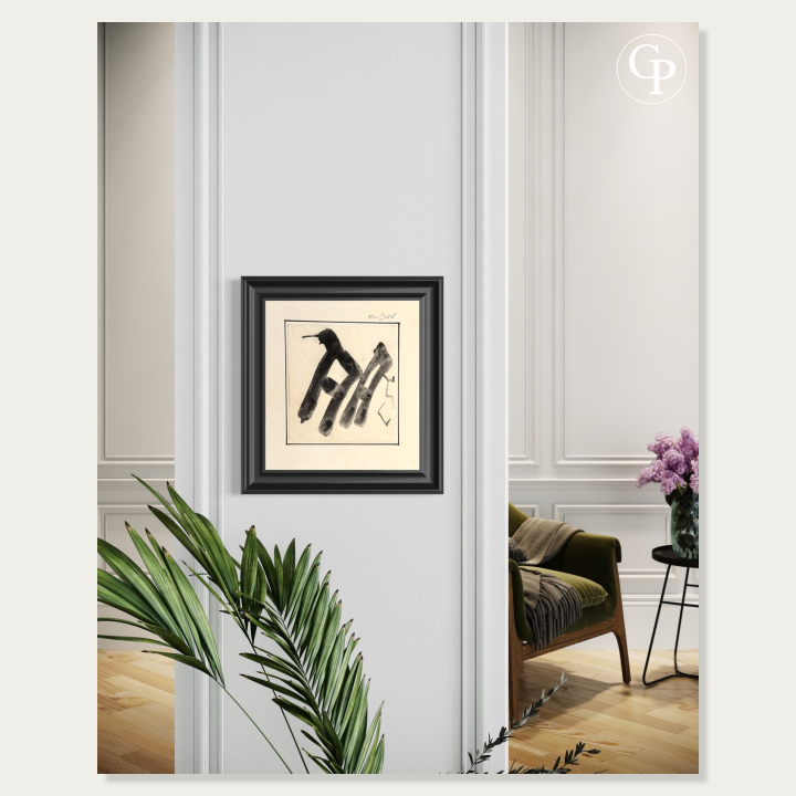 Framed minimalist black ink artwork by Hanna Ben-Dov on a white pillar, with a green armchair, parquet floor, and purple flowers in the background. | Œuvre minimaliste à l'encre noire de Hanna Ben-Dov encadrée sur un pilier blanc, avec un fauteuil vert, du parquet et des fleurs violettes en arrière-plan.