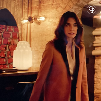Lampe Skyscraper Art Déco allumée dans un décor de la série Netflix Kaleidoscope, avec  l'actrice PAZ VEGA en premier plan.