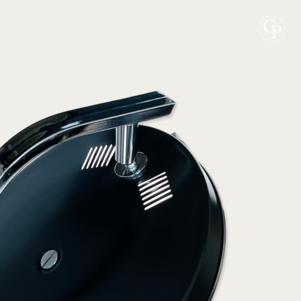Gros plan sur le dessus du réflecteur en laque anthracite, les ouïes d'aération et la rotule en acier chromé de la lampe MaOf FASE | Close-up of the textured anthracite shade top, cooling slots and chrome swivel joint of the MaOf FASE lamp