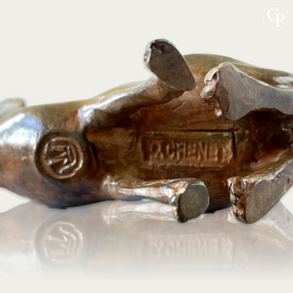 Close-up underside view of the rabbit bronze sculpture by Pierre Chenet showing the clear signature "P. CHENET" and foundry mark | Vue rapprochée de dessous du lapin aux grandes oreilles cubiste en bronze par Pierre Chenet montrant la signature "P. CHENET" bien visible et le cachet de fonderie