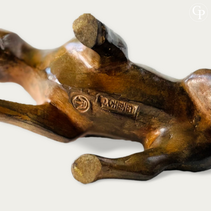 Close-up underside view of the cubist bull bronze sculpture by Pierre Chenet showing the clear signature "P. CHENET" and foundry mark, rich acid patina visible on the bronze. | Vue rapprochée de dessous du taureau cubiste en bronze par Pierre Chenet montrant la signature "P. CHENET" bien visible et le cachet de fonderie, belle patine à l’acide sur le bronze.