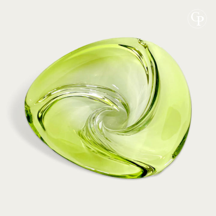 Vue de dessus du centre de table Patelle en cristal lime et chartreuse de Val Saint Lambert, mettant en valeur son mouvement de spirale et vortex organique unique, circa 1965. | Top view of the Patelle crystal centerpiece by Val Saint Lambert in lime chartreuse green, highlighting its unique organic vortex and spiral movement, circa 1965.
