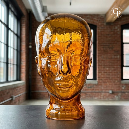Tête de mannequin vintage en verre moulé ambre cognac style Space Age 1970 posée de face | Vintage 1970s Space Age amber cognac molded glass mannequin head front view