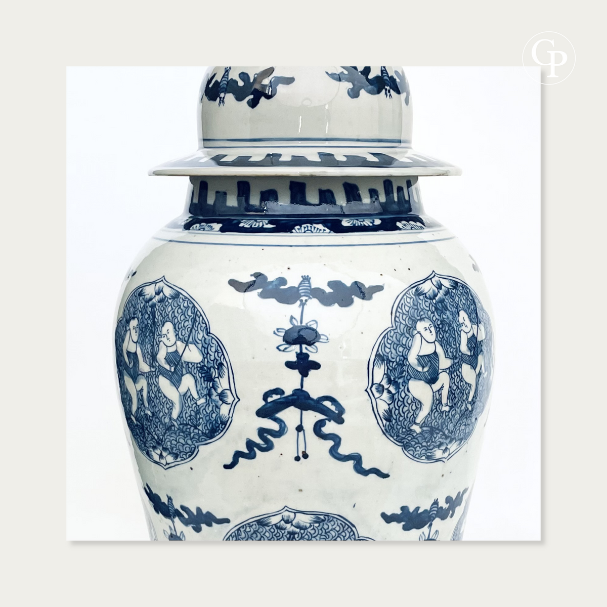 Gros plan sur la partie supérieure du vase en porcelaine chinoise bleu et blanc montrant le motif du nœud sans fin entouré des cartouches d'enfants pêcheurs | Close-up of the upper section of the Chinese blue and white porcelain vase showing the endless knot symbol framed by fishing children medallions