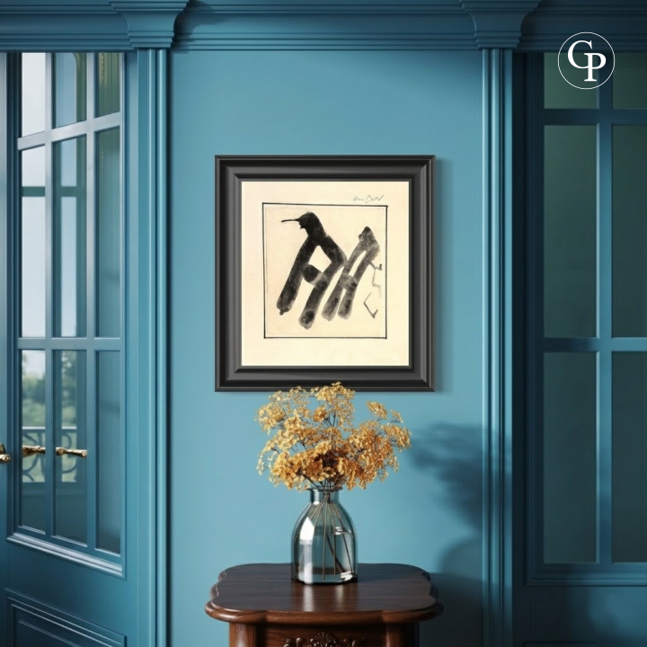 Framed minimalist black ink abstract calligraphy artwork by Hanna Ben-Dov on a blue living room wall with a wooden side table and dried flowers. | Encre abstraite minimaliste noire de Hanna Ben-Dov encadrée, sur un mur bleu de salon avec une table d'appoint en bois et des fleurs séchées.