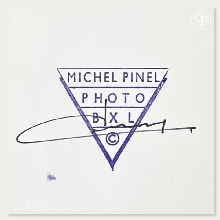Gros plan sur le verso de la photographie avec le tampon d'atelier triangulaire bleu Michel Pinel Photo BXL et la signature manuscrite de l'artiste. | Close-up view of the back of the photograph showcasing Michel Pinel's blue triangular studio stamp and his authentic handwritten signature.